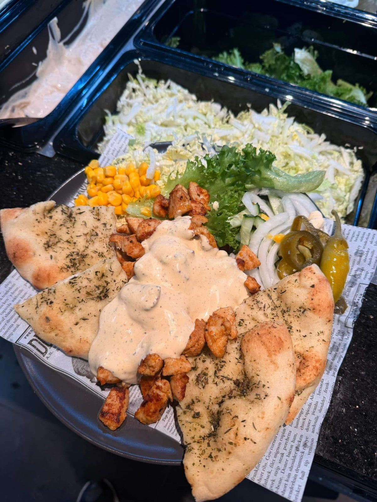 Tallerken med grillet kylling, dressing, hvitløksbrød og salat med mais og jalapeños fra JAFS Larvik